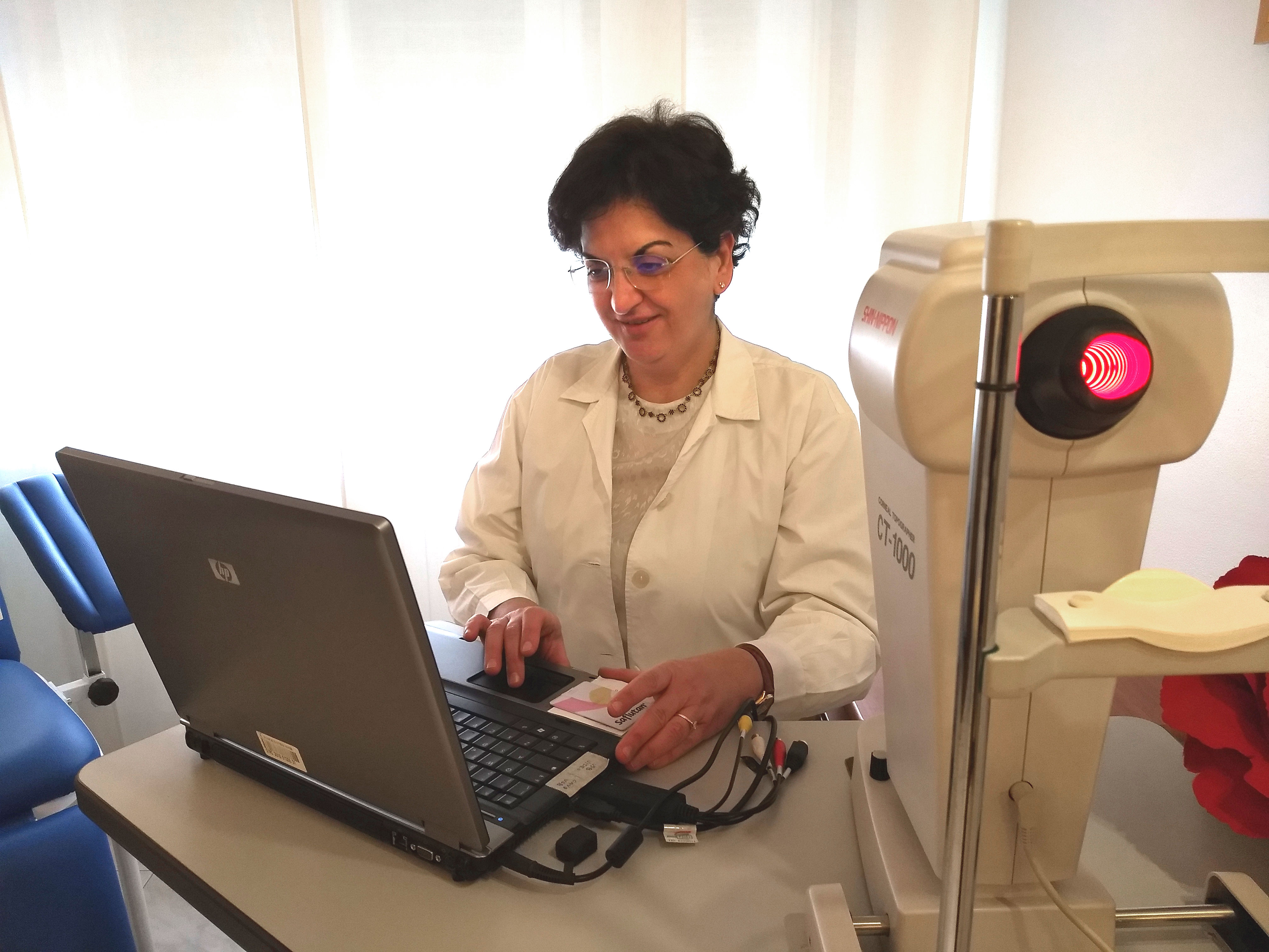 Dott.ssa oculista HAla Fallah allo strumento che produce un'analisi della cornea, topografia corneale